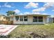 Rear view of the home with partial fencing and lush grass at 7810 Pineapple Ln, Port Richey, FL 34668