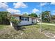 Charming single-story home with a brick exterior, complemented by a well-maintained lawn and mature trees at 7810 Pineapple Ln, Port Richey, FL 34668