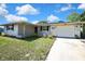 Charming single Gathering home with a brick facade, driveway, and front yard landscaping at 7810 Pineapple Ln, Port Richey, FL 34668