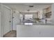 Functional kitchen with white appliances and a pass-through to the living area at 7810 Pineapple Ln, Port Richey, FL 34668