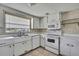 Clean kitchen with standard appliances, light cabinetry, and tile flooring at 7810 Pineapple Ln, Port Richey, FL 34668