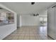 Bright living room with tile flooring, ceiling fan, and open layout to the kitchen at 7810 Pineapple Ln, Port Richey, FL 34668