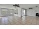 Open-concept living area with tile flooring, multiple ceiling fans, and sliding glass doors at 7810 Pineapple Ln, Port Richey, FL 34668