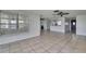 Large living space with tile floor, neutral walls and open layout to kitchen and entryway at 7810 Pineapple Ln, Port Richey, FL 34668