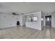 Spacious living area with neutral tile flooring, open to the kitchen and front door at 7810 Pineapple Ln, Port Richey, FL 34668