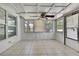 Bright sun room filled with windows and neutral tile flooring at 7810 Pineapple Ln, Port Richey, FL 34668