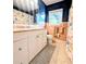 A bright bathroom with a granite countertop vanity, pink tile, a window, and a shower with patterned curtains at 8260 32Nd N Ave, St Petersburg, FL 33710