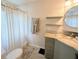 This full bathroom features an updated vanity, floating shelves, and a shower with a patterned curtain at 8260 32Nd N Ave, St Petersburg, FL 33710
