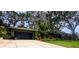 Landscaped front yard with lush tropical plants and a modern garage door enhance this charming home's curb appeal at 8260 32Nd N Ave, St Petersburg, FL 33710