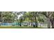 A large playground with green safety surfacing is protected by mature shady trees at 8260 32Nd N Ave, St Petersburg, FL 33710