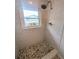 Shower boasts a stone floor, updated fixture and window to allow plenty of natural light at 8260 32Nd N Ave, St Petersburg, FL 33710