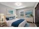 Staged bedroom with blue accents, neutral walls, and art; bright and welcoming at 8603 N 9Th St, Tampa, FL 33604