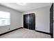 Bedroom featuring gray walls, new flooring, and black baseboards at 8603 N 9Th St, Tampa, FL 33604