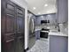 Modern kitchen with gray cabinets, stainless steel appliances, and patterned tile backsplash at 8603 N 9Th St, Tampa, FL 33604