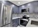 Kitchen with stainless steel refrigerator, gray cabinets, and a mosaic tile backsplash at 8603 N 9Th St, Tampa, FL 33604