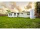 Spacious backyard with lush lawn, privacy fence, and home's exterior at 9020 Gray Fox Ln, Port Richey, FL 34668