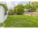 Expansive backyard featuring lush green grass, mature trees, and a privacy fence at 9020 Gray Fox Ln, Port Richey, FL 34668