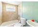 Bathroom with a tub, toilet, and sink with a window above the tub at 9020 Gray Fox Ln, Port Richey, FL 34668