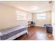 Bedroom featuring wood floors, large windows, a bed, and simple furnishings at 9020 Gray Fox Ln, Port Richey, FL 34668