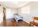 Simple bedroom with a bed, hardwood floors, chair, and a bright window at 9020 Gray Fox Ln, Port Richey, FL 34668