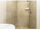 Tiled shower with a shower head and soap dish; neutral tones and functional design at 9020 Gray Fox Ln, Port Richey, FL 34668