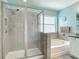 Bathroom featuring glass enclosed shower and soaking tub with decorative window at 1022 Montgomery Bell Rd, Wesley Chapel, FL 33543
