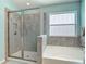 Bathroom featuring glass-enclosed tile shower, soaking tub, and decorative window at 1022 Montgomery Bell Rd, Wesley Chapel, FL 33543