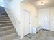 Welcoming foyer with stairs, tile flooring, and a bench with storage, offering style and functionality at 1022 Montgomery Bell Rd, Wesley Chapel, FL 33543
