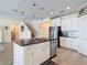Modern kitchen features stainless appliances, granite counters, white cabinets, and island sink at 1022 Montgomery Bell Rd, Wesley Chapel, FL 33543