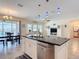 Open concept kitchen features stainless appliances, granite counters, and island with seating overlooking the living area at 1022 Montgomery Bell Rd, Wesley Chapel, FL 33543