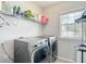 Modern laundry room with updated washer and dryer set under a convenient shelving unit at 1022 Montgomery Bell Rd, Wesley Chapel, FL 33543
