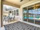 Covered patio with comfortable seating and sliding glass doors overlooking a sparkling pool and serene lake view at 1022 Montgomery Bell Rd, Wesley Chapel, FL 33543