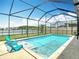 Sparkling screened pool with comfortable lounge chairs, set against a backdrop of a serene lake and lush greenery at 1022 Montgomery Bell Rd, Wesley Chapel, FL 33543