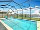 This screened-in pool features a relaxing view of the nearby lake, sunny sitting area, and fountain at 1022 Montgomery Bell Rd, Wesley Chapel, FL 33543