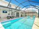 Covered pool and patio area features ceiling fan, television, and grill at 1022 Montgomery Bell Rd, Wesley Chapel, FL 33543