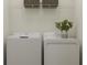 Bright laundry room features side-by-side washer and dryer and overhead wire rack shelving for convenient storage at 10233 Trumpet Honeysuckle Way, San Antonio, FL 33576