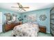 Tranquil bedroom featuring blue walls, floral bedding, and decorative wall art at 10400 112Th Way, Largo, FL 33778
