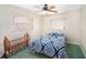 Neutral bedroom with blue patterned duvet cover, a ceiling fan and two windows at 10400 112Th Way, Largo, FL 33778