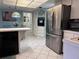 Bright kitchen with stainless steel refrigerator, tile floor, and modern appliances at 10400 112Th Way, Largo, FL 33778