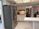 Well-lit kitchen featuring stainless steel refrigerator, white cabinets, and tile flooring at 10400 112Th Way, Largo, FL 33778