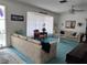 Bright living room featuring floral sofas, blue carpet, and a large window with sheer curtains at 10400 112Th Way, Largo, FL 33778