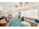 Inviting living room with a floral couch, turquoise carpet, and a bay window adorned with butterfly decorations at 10400 112Th Way, Largo, FL 33778