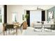 Open-concept living and dining area with modern furnishings, bright lighting, and sleek ceiling fan at 10812 Keato Beach Ct, Tampa, FL 33647