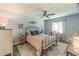 Bright bedroom with light blue walls, ceiling fan, desk, and nicely decorated with bed, dresser, and area rug at 1100 E Bay Dr # 96, Largo, FL 33770