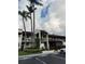 Condominium building exterior featuring mature trees, landscaping, and dedicated parking at 1100 E Bay Dr # 96, Largo, FL 33770