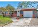 Inviting home exterior with a lush garden, and an attached garage with a well-paved driveway at 11348 59Th Ter, Seminole, FL 33772