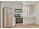 Well-lit kitchen features white cabinets, stainless steel appliances and eat-in area at 116 24Th S Ave, St Petersburg, FL 33705