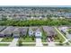 A high aerial view displays a sprawling neighborhood with lush greenery and a serene pond nearby at 1203 Custer Bayou Street, Ruskin, FL 33570