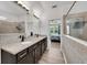 Bathroom with double granite vanity, tile flooring, and view to bedroom at 1203 Custer Bayou Street, Ruskin, FL 33570