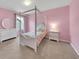 Pink bedroom with a canopy bed, complemented by matching furniture at 1203 Custer Bayou Street, Ruskin, FL 33570